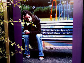 Woman leaning on a pole while sitting on a bench. she looks depressed.